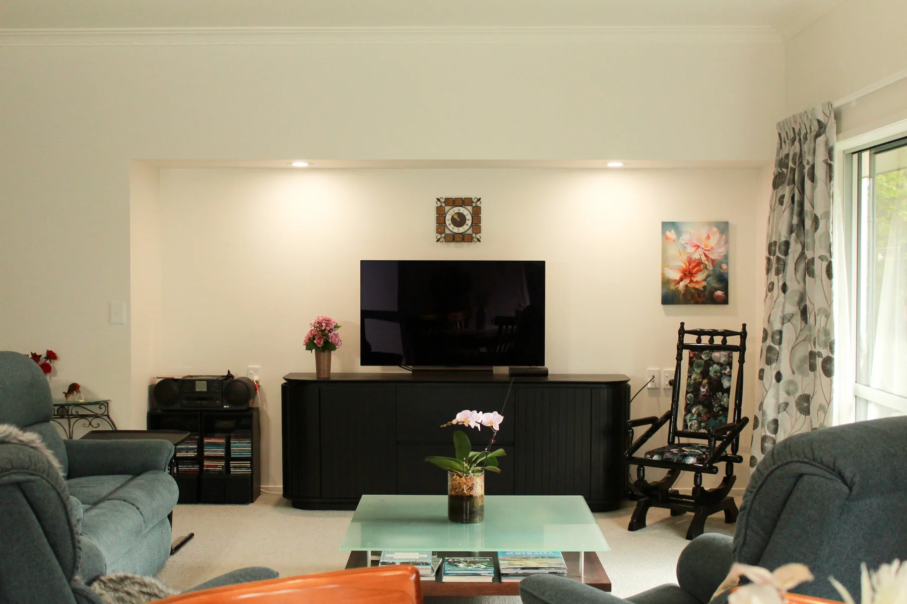 A cottage living room with comfortable seating and a garden outlook