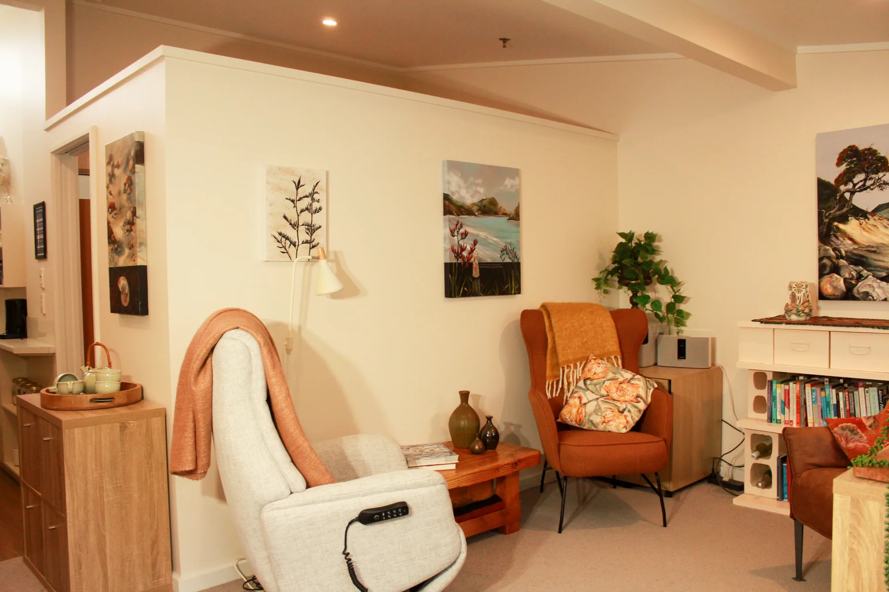 A pavilion studio living area with armchairs, bookshelves and a resident's own pictures