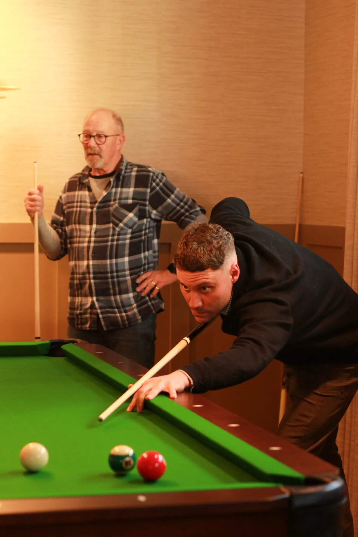 Two residents playing a game of snooker in the community centre
