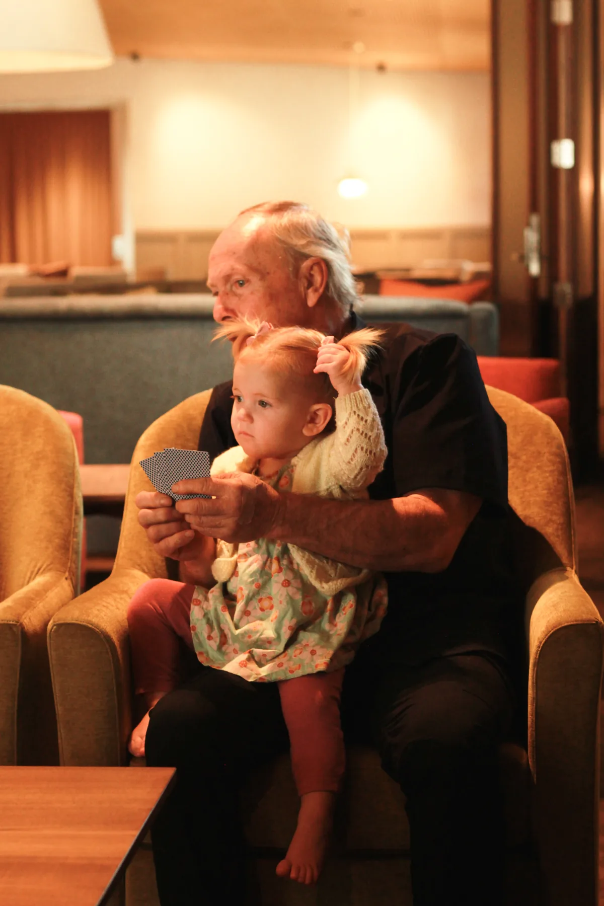 A resident enjoying a visit from a young family member in the lounge