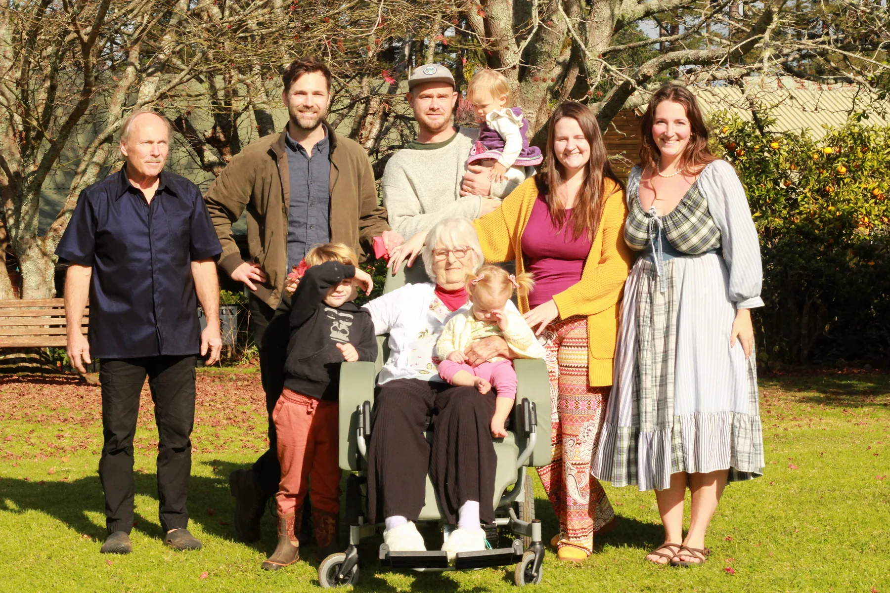 Three generations of a family gathered around a resident in the village grounds