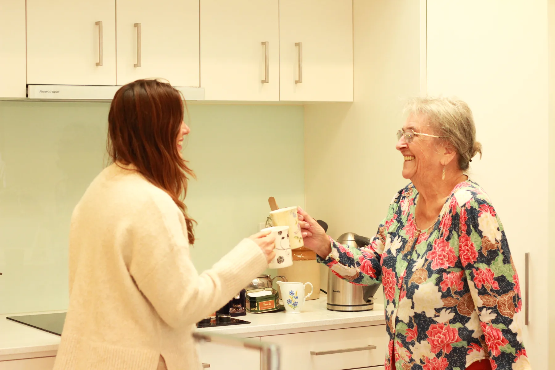 A resident and a staff member making a pot of tea together in the kitchen