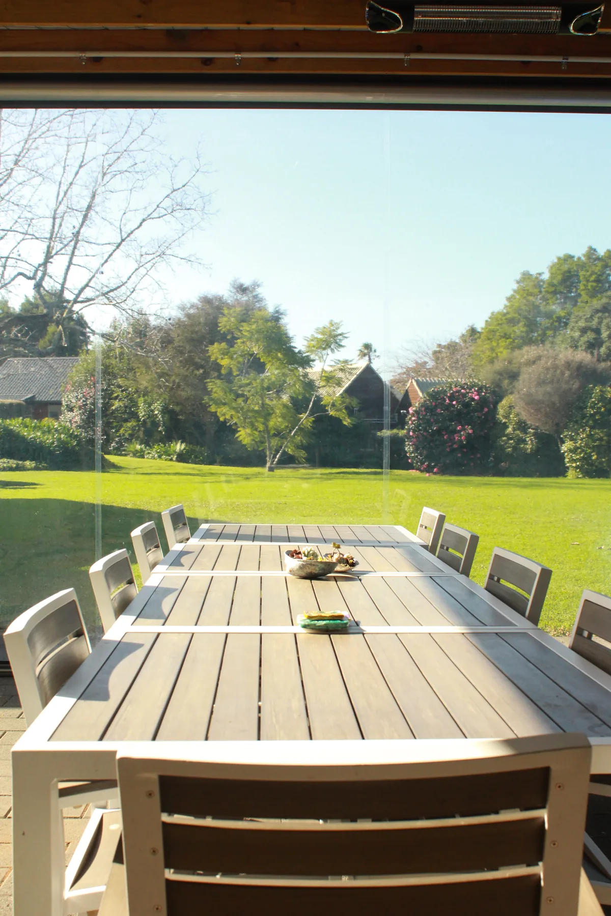 A long outdoor table looking out over the village lawns and trees